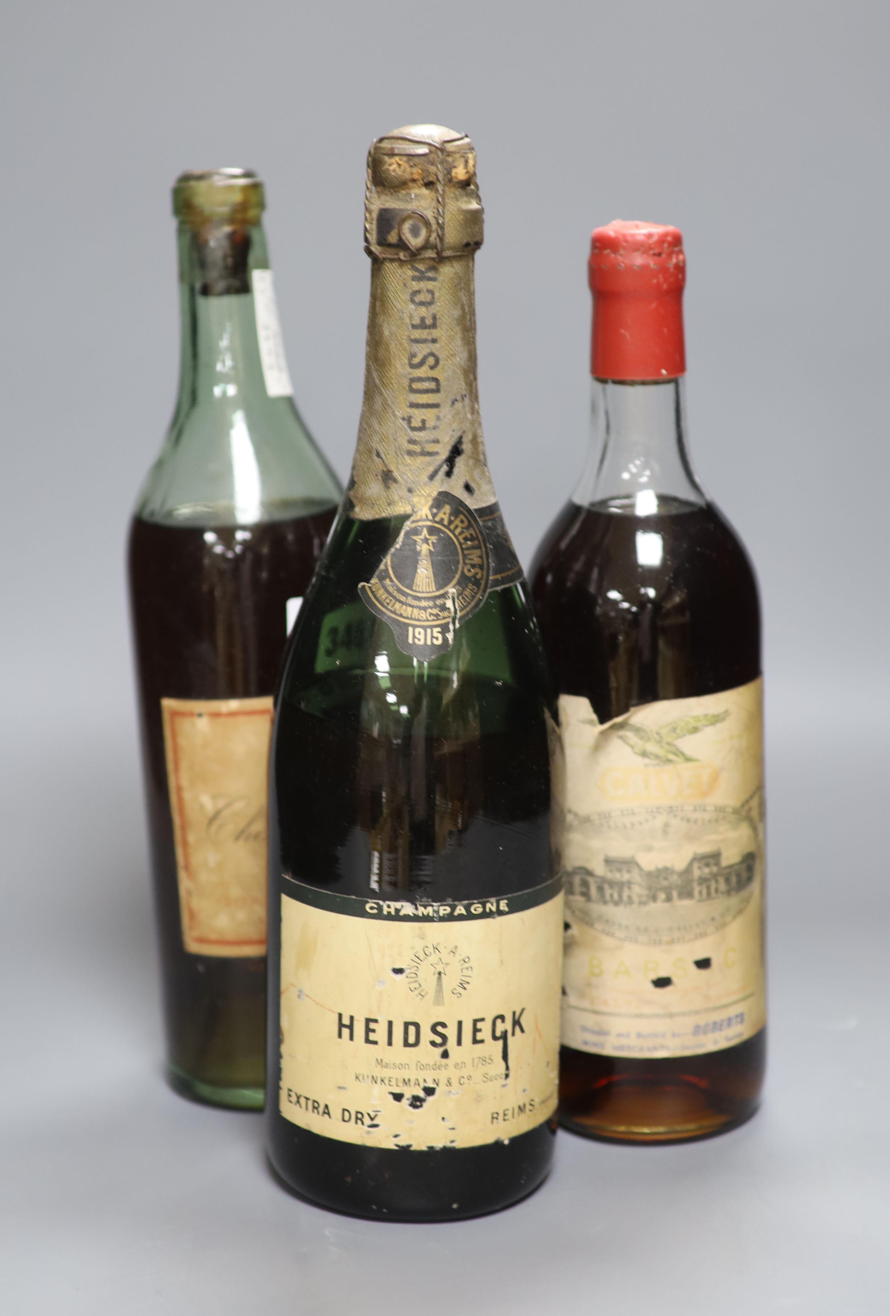 A 1915 bottle of Heidsieck, a bottle of Barsac and a K.P. Charente brandy by Peters Hall & Co, London